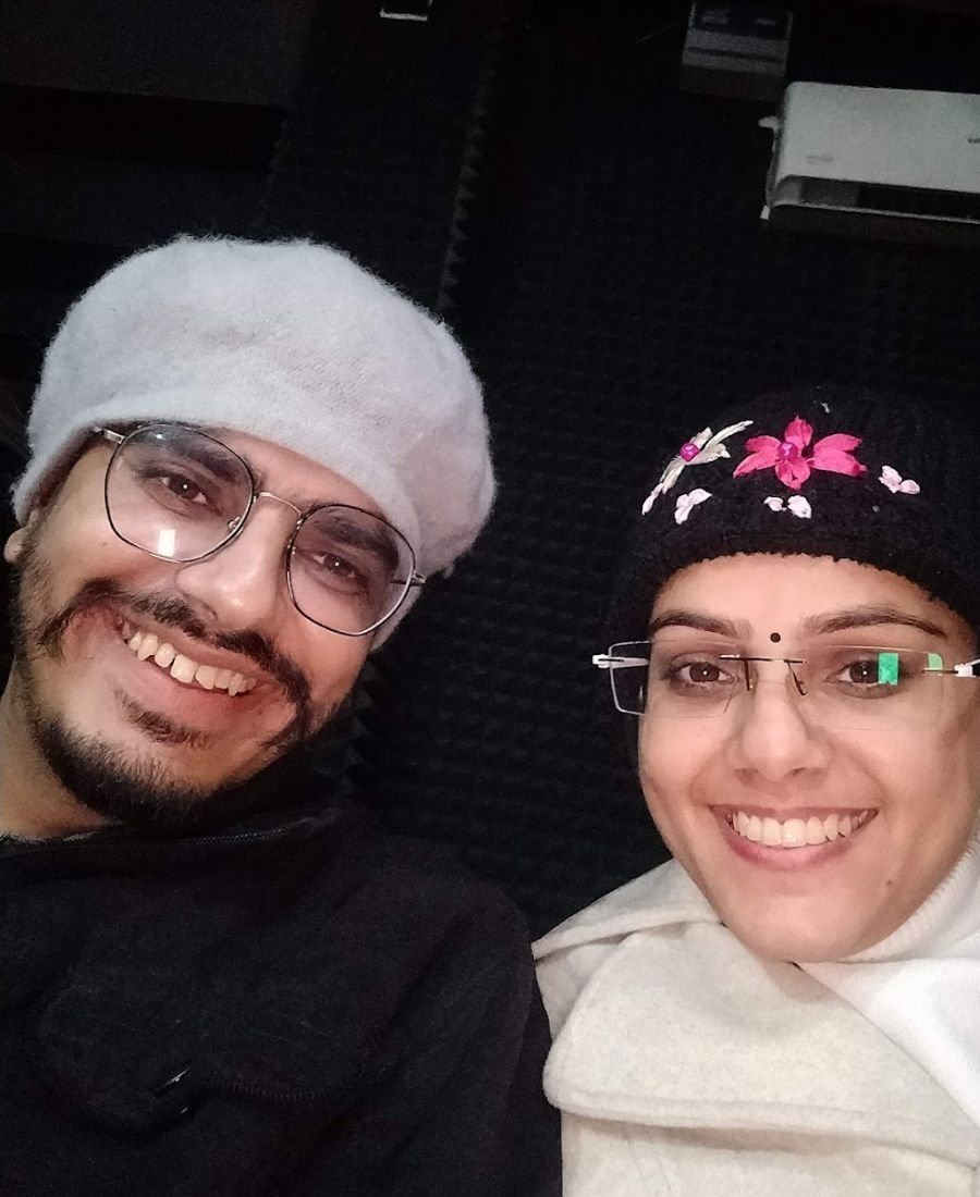 Divyanshi and Nikunj smiling together in winter caps and glasses