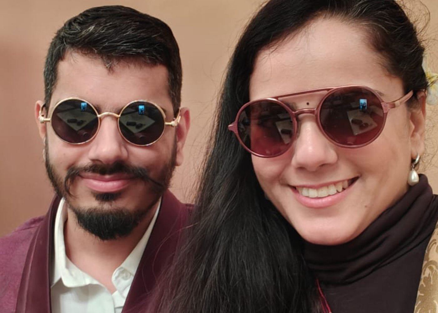 Nikunj and Divyanshi close together, both wearing sunglasses, smiling