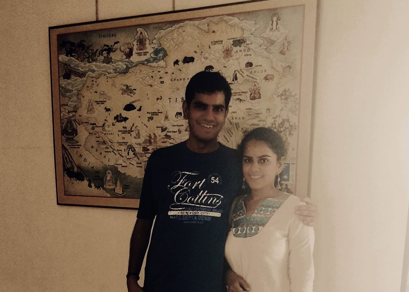 Nikunj and Divyanshi standing together in front of a large framed wall map